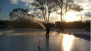 Morning coat of the park rink with a firehose